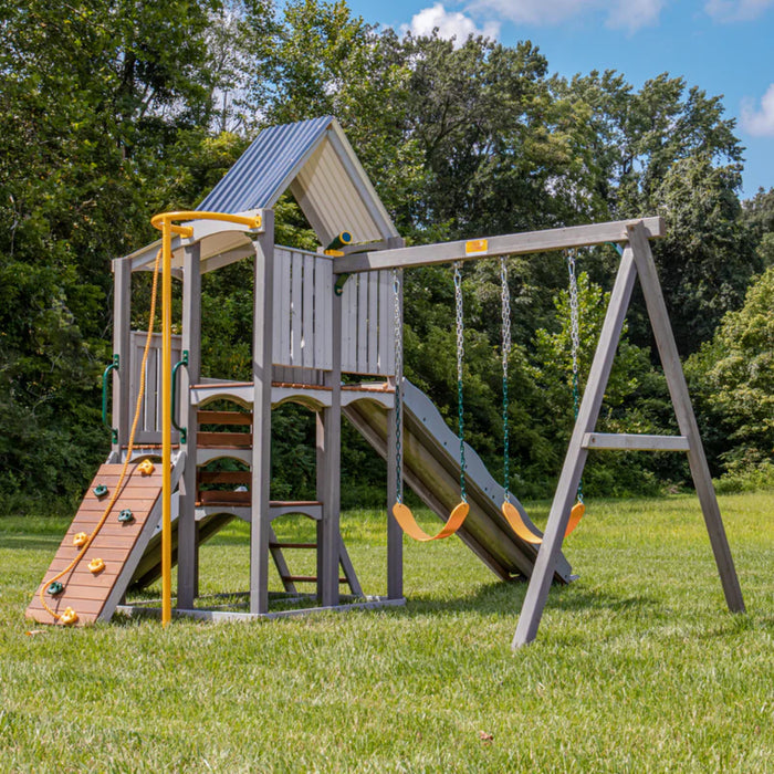 Jack and June Haven outdoor wooden playset with swings, slide, climbing ladder, steps, telescope and lookout ramp with cover, firemans pole. Playset set in the garden full view