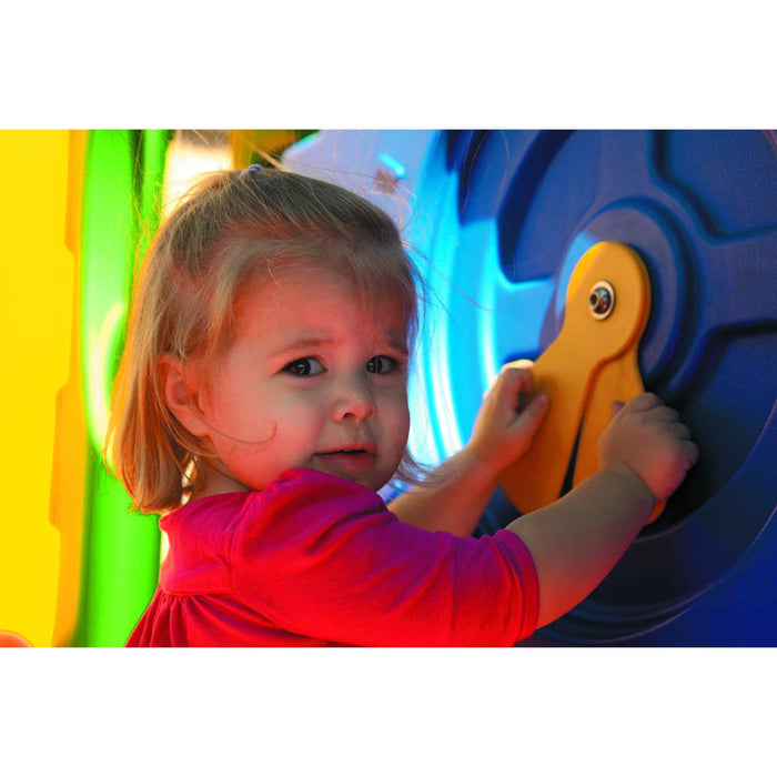 Ultraplay discovery center sapling toddler playset , image zoomed in on a girl toddler facing the camera playing with two orange arms that look like a clock hands 